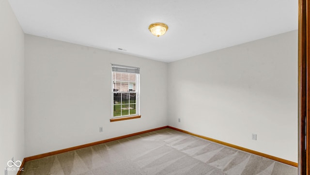 empty room with baseboards and light colored carpet