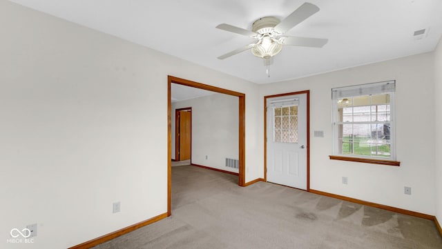 unfurnished room featuring visible vents, ceiling fan, light carpet, and baseboards