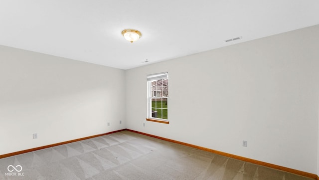 empty room with baseboards, visible vents, and carpet floors