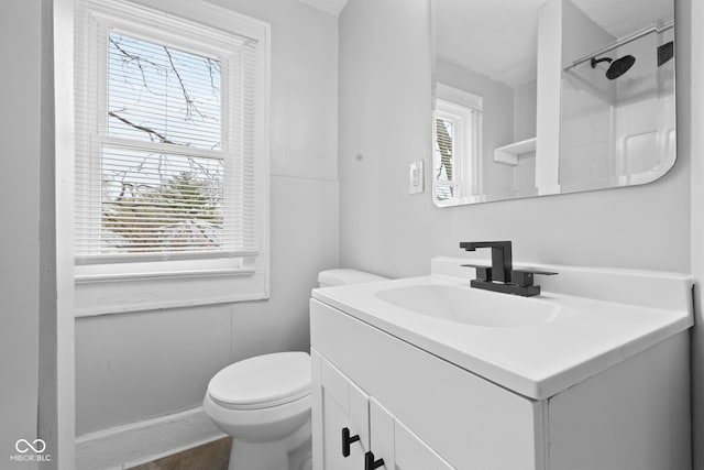 bathroom with vanity, toilet, and a healthy amount of sunlight