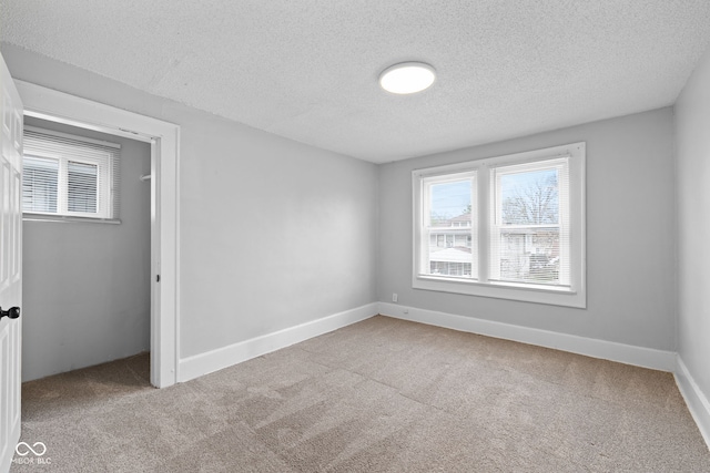 unfurnished bedroom featuring carpet floors, baseboards, and a textured ceiling