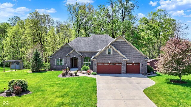 craftsman house with brick siding, a garage, driveway, and a front lawn