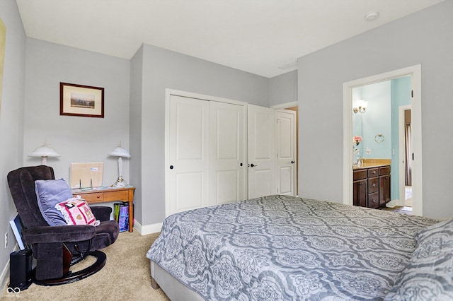 bedroom with carpet flooring, baseboards, ensuite bath, and a closet
