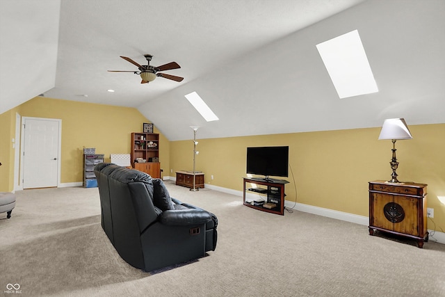 living room featuring baseboards, a ceiling fan, carpet, and lofted ceiling with skylight