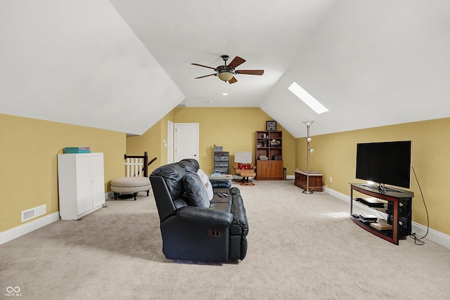 living area featuring a ceiling fan, visible vents, carpet floors, baseboards, and lofted ceiling with skylight