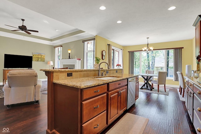 kitchen with dark wood-style flooring, light stone counters, a sink, baseboards, and stainless steel dishwasher
