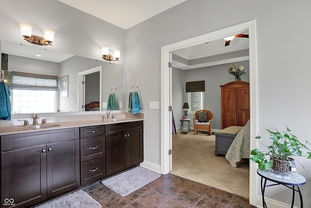 full bath featuring a sink, baseboards, ensuite bath, and double vanity
