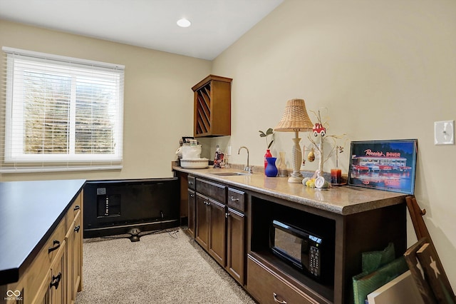 kitchen with black microwave, light carpet, a sink, light countertops, and recessed lighting