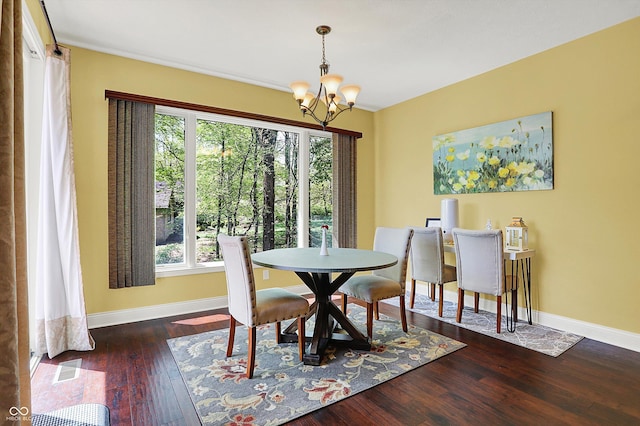 dining room featuring baseboards, a wealth of natural light, hardwood / wood-style floors, and a notable chandelier