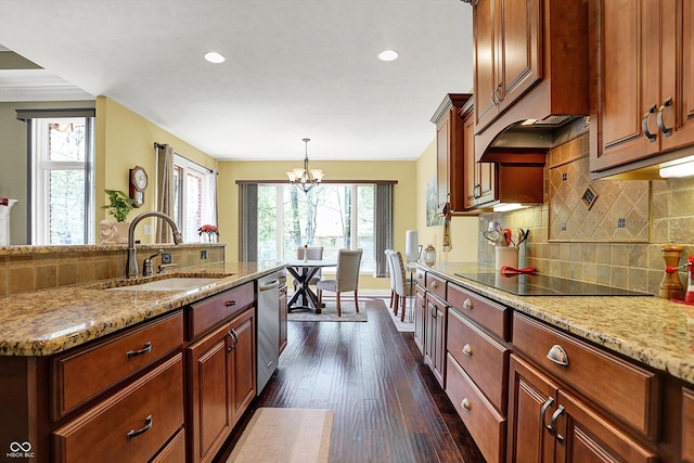 kitchen featuring dark wood-style flooring, black electric stovetop, a sink, dishwasher, and a chandelier