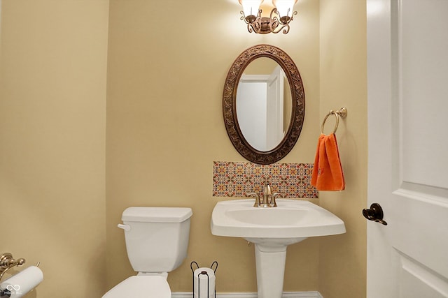 half bath with toilet and baseboards