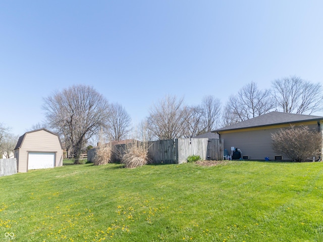 view of yard with an outdoor structure, fence, and a detached garage