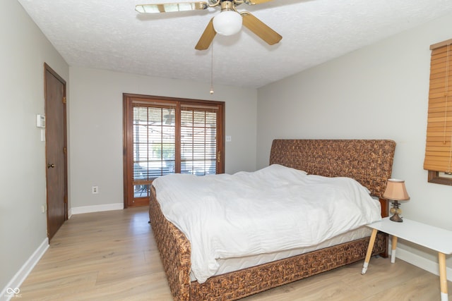 bedroom with a ceiling fan, baseboards, light wood finished floors, and a textured ceiling