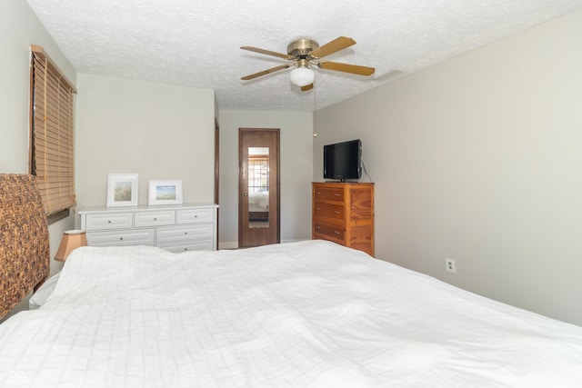 bedroom with ceiling fan and a textured ceiling