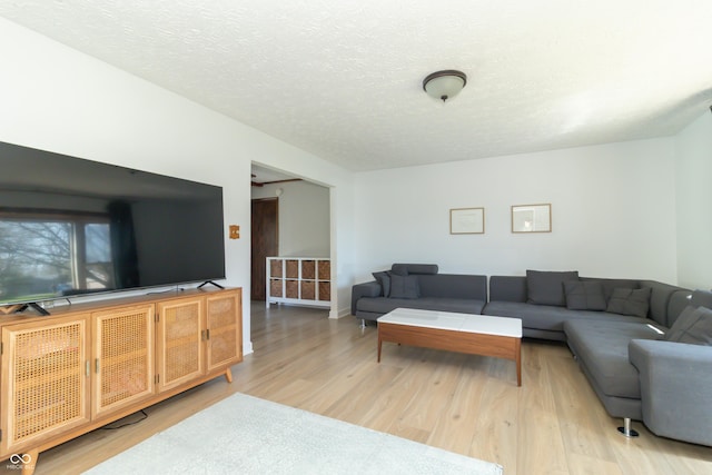 living area with light wood-style floors and a textured ceiling