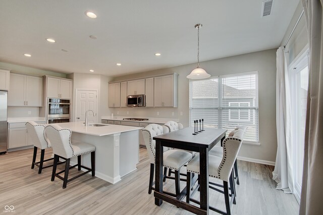 3799 Hoosier Down Dr, Bargersville, IN 46106 - kitchen with a sink, a breakfast bar, light countertops, appliances with stainless steel finishes, and visible vents