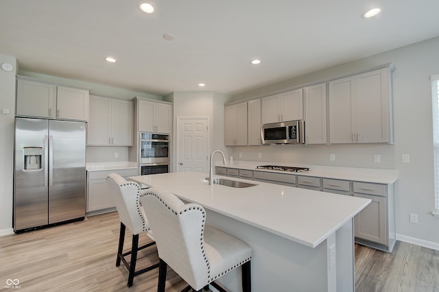 3799 Hoosier Down Dr, Bargersville, IN 46106 - kitchen featuring light wood finished floors, gray cabinets, stainless steel appliances, and a sink