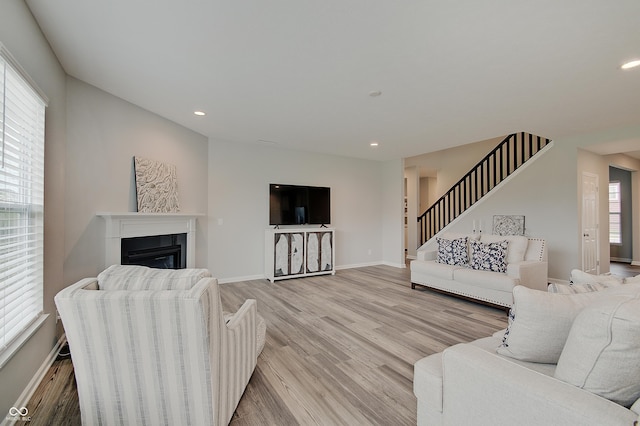 3799 Hoosier Down Dr, Bargersville, IN 46106 - living room with baseboards, a glass covered fireplace, stairs, and light wood finished floors
