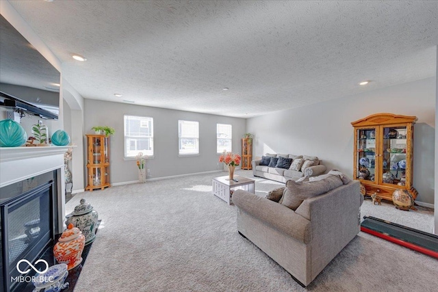5839 Altar Bell Cir, Greenwood, IN 46143 - living room with recessed lighting, carpet flooring, a textured ceiling, and a glass covered fireplace