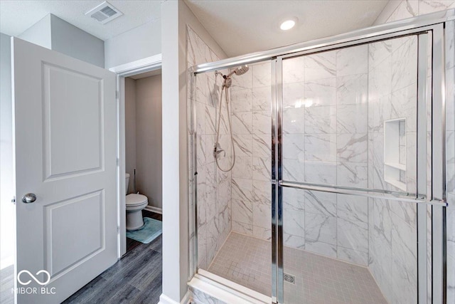 5839 Altar Bell Cir, Greenwood, IN 46143 - bathroom with visible vents, wood finished floors, toilet, and a shower stall
