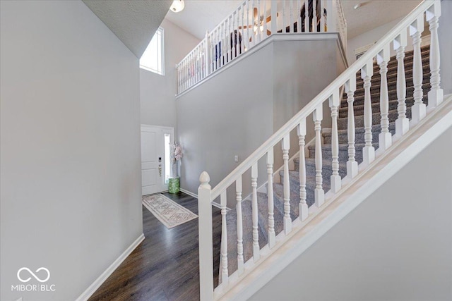 5839 Altar Bell Cir, Greenwood, IN 46143 - staircase featuring baseboards, wood finished floors, and a towering ceiling