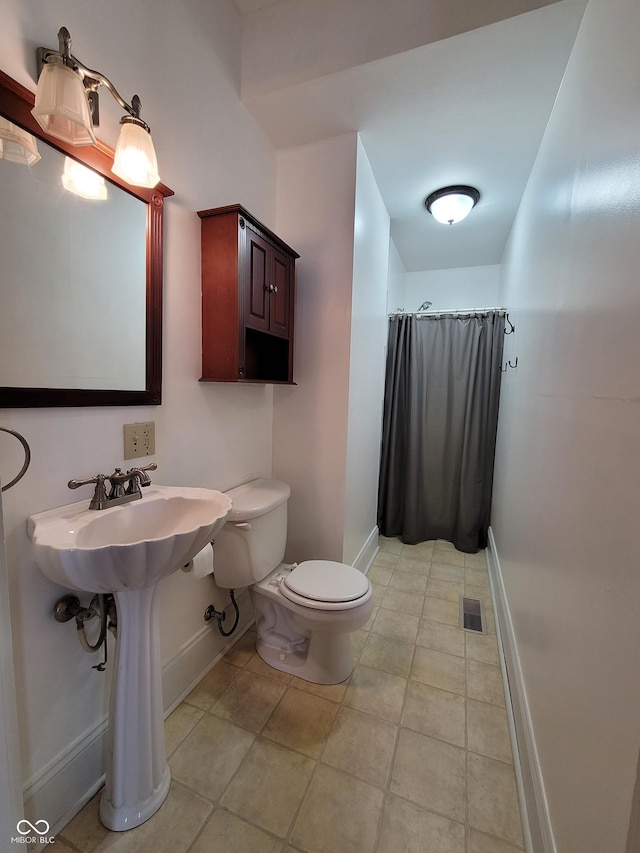 2628 N 150 E, Rushville, IN 46173 - bathroom with tile patterned floors, toilet, curtained shower, and baseboards