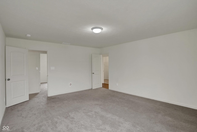 carpeted empty room featuring visible vents