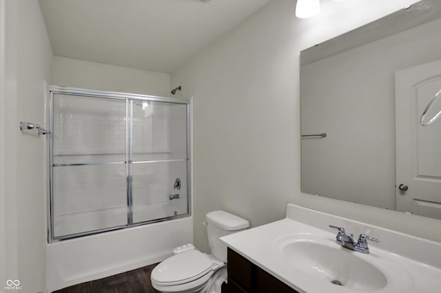 full bath featuring combined bath / shower with glass door, vanity, toilet, and wood finished floors