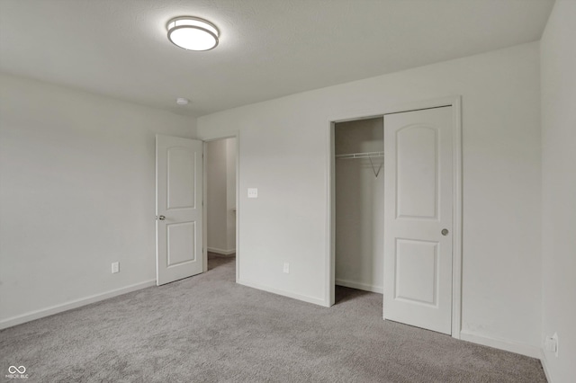 unfurnished bedroom with a closet, baseboards, and carpet flooring