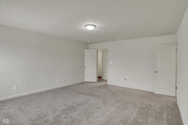 empty room featuring carpet floors, baseboards, and a textured ceiling
