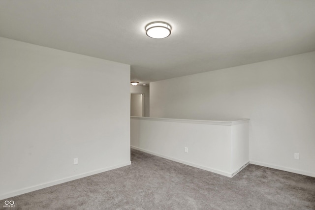 carpeted spare room featuring baseboards