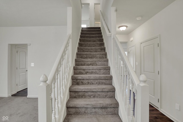 staircase featuring baseboards and wood finished floors