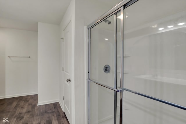full bath featuring an enclosed shower, baseboards, and wood finished floors