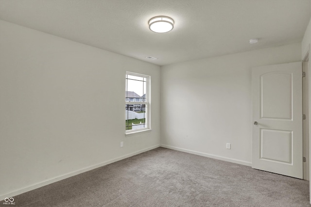carpeted empty room with visible vents and baseboards