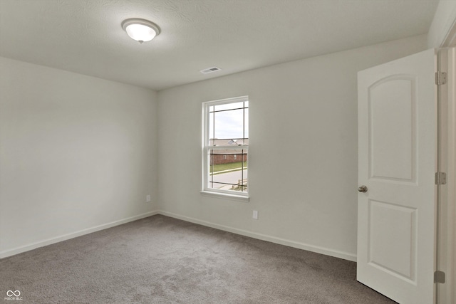 unfurnished room featuring visible vents, baseboards, and carpet flooring