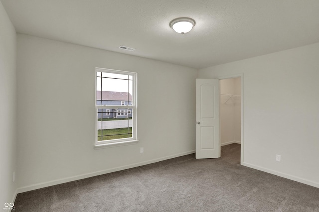 carpeted empty room with visible vents and baseboards