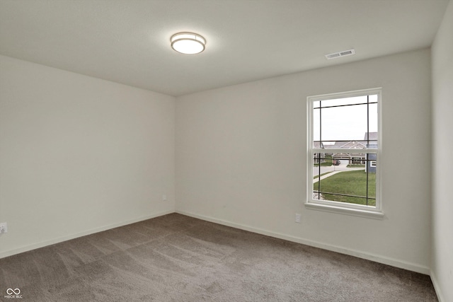 carpeted spare room with visible vents and baseboards