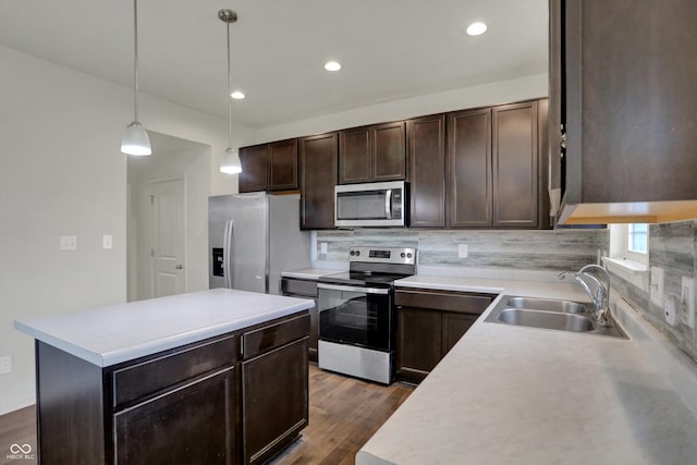 kitchen featuring dark brown cabinetry, light countertops, dark wood finished floors, stainless steel appliances, and a sink