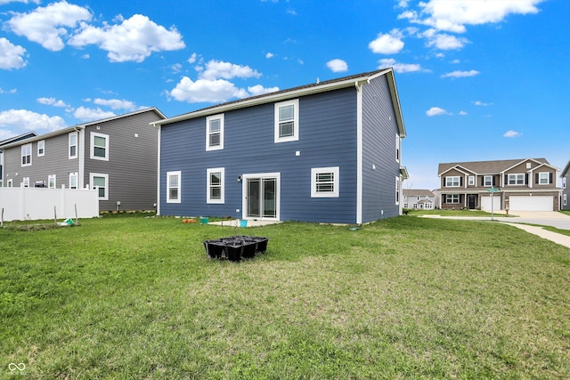 rear view of property featuring a yard, fence, and a residential view