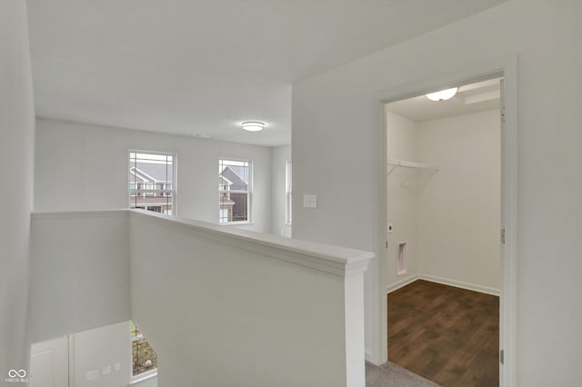 hall featuring visible vents and an upstairs landing