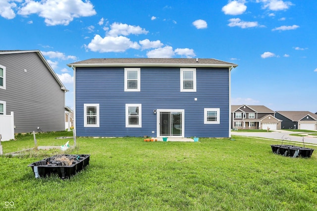 back of house featuring a yard and a fire pit