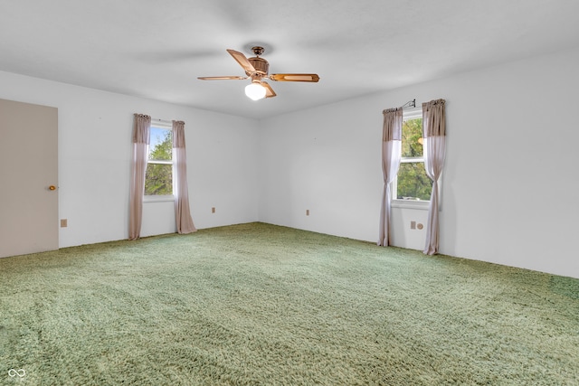 carpeted spare room with ceiling fan and a healthy amount of sunlight