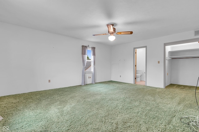 unfurnished bedroom featuring carpet floors, ceiling fan, visible vents, and ensuite bathroom