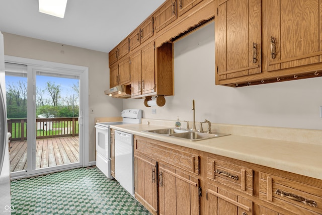 kitchen with white appliances, under cabinet range hood, a sink, and light countertops