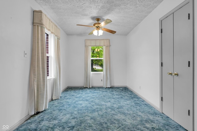 unfurnished bedroom featuring carpet floors, a textured ceiling, and baseboards