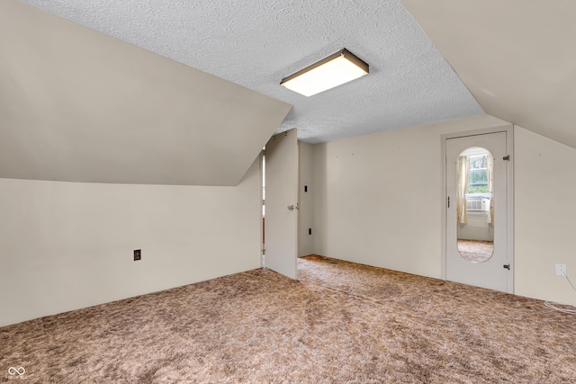 bonus room with carpet floors, a textured ceiling, and vaulted ceiling