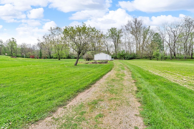 view of yard with driveway and a rural view