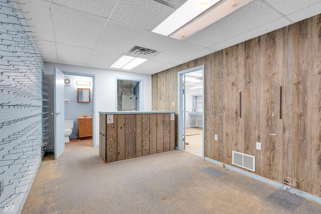 bar featuring a drop ceiling, wood walls, and visible vents