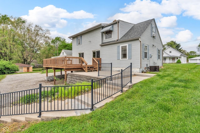 rear view of house featuring roof with shingles, a lawn, a deck, central AC, and fence