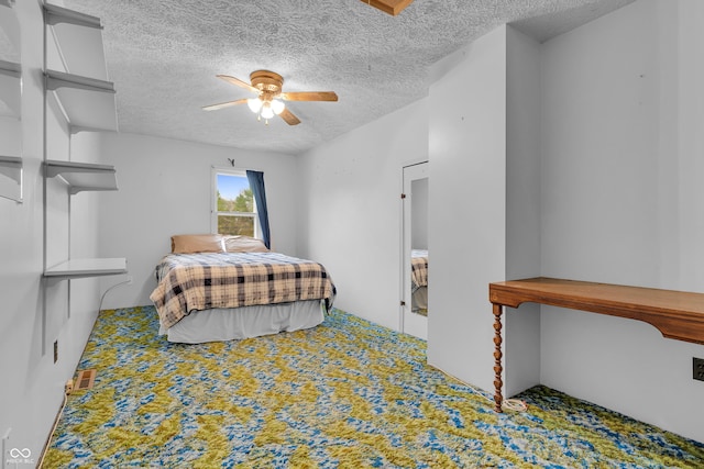 bedroom with ceiling fan, carpet, and a textured ceiling